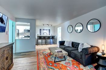 A living room with a couch, a coffee table, and a rug at Woodlake Apartments, Kirkland 98034